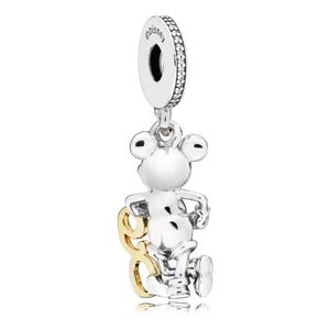 May include: A silver charm featuring Mickey Mouse with a gold number 80. The charm has a loop at the top with the word "disney" and is embellished with small, clear stones. The Mickey Mouse figure is in a running pose.
