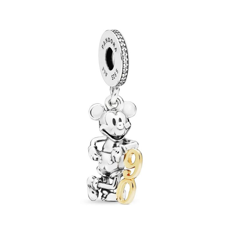 May include: A silver charm featuring Mickey Mouse with a gold-colored "90" attached. The charm has a loop at the top for attachment to a bracelet or necklace. The charm is a collectible item.