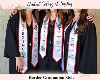 May include: Group of people wearing black graduation gowns and white sashes with red trim. The sashes read "NURSING" and feature a school logo and graduate names. Text at the top says "United Colors of Sashes" and at the bottom "Border Graduation Stole."