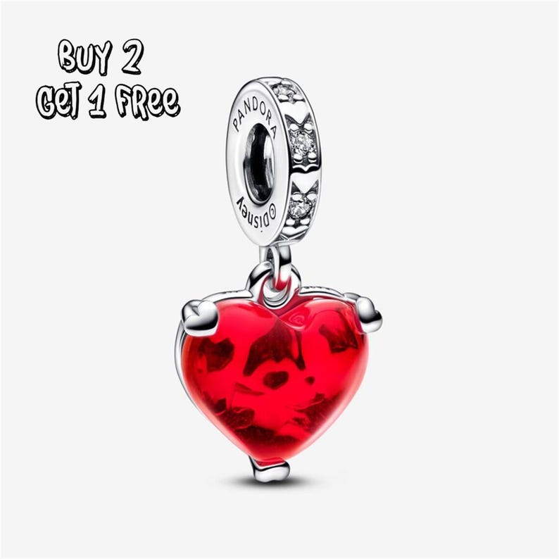 May include: A silver charm featuring a red heart-shaped pendant. The charm is engraved with the words "Pandora" and "Disney". The text "BUY 2 GET 1 FREE" is visible in the upper left corner.