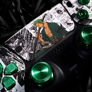 Pode incluir: Controlador de jogos preto com detalhes verdes e um design personalizado em estilo mangá. O controlador apresenta um personagem com cabelo verde e botões verdes. O design está em um fundo preto.