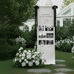 May include: A white memorial banner with the text "RESERVED IN LOVE MEMORY" and a dove illustration. The banner displays six black and white photos. Black ribbons are tied at the top. White flowers and greenery surround the banner.