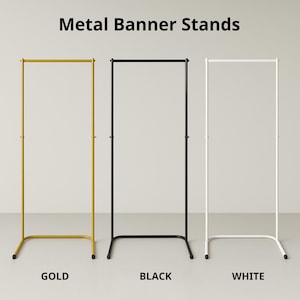 May include: Three metal banner stands in gold, black, and white. The stands have a rectangular frame with a horizontal bar at the top. The text "Metal Banner Stands" is at the top of the image, with the colours labelled below each stand.