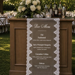 Op de afbeelding: Een rechthoekig, doorschijnend barmenu-bord met witte kanten afwerking langs de verticale randen. De tekst vermeldt Bar Menu, Old Fashioned, Spicy Pineapple Margarita, Cucumber Collins en Sidecar met de bijbehorende ingrediënten in het wit.