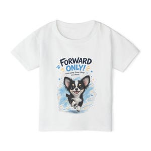 May include: A white short-sleeved t-shirt featuring a graphic of a black and white puppy running. Above the puppy, the text reads FORWARD ONLY! and Keep going. Great things are ahead! The design includes blue brush strokes, stars, and paw prints.