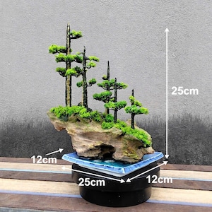 May include: A miniature bonsai tree, approximately 10 inches tall, with green foliage and a textured, light brown rock base. The bonsai sits on a blue and white ceramic tray, 5 inches by 5 inches, atop a black base, 10 inches wide.