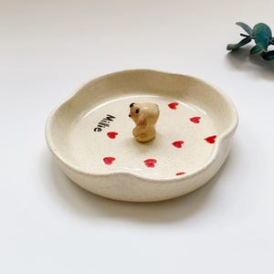 May include: A set of three ceramic mugs with a speckled, matte finish in cream, light grey, and dark grey. Each mug has a simple, minimalist design and a rounded handle.