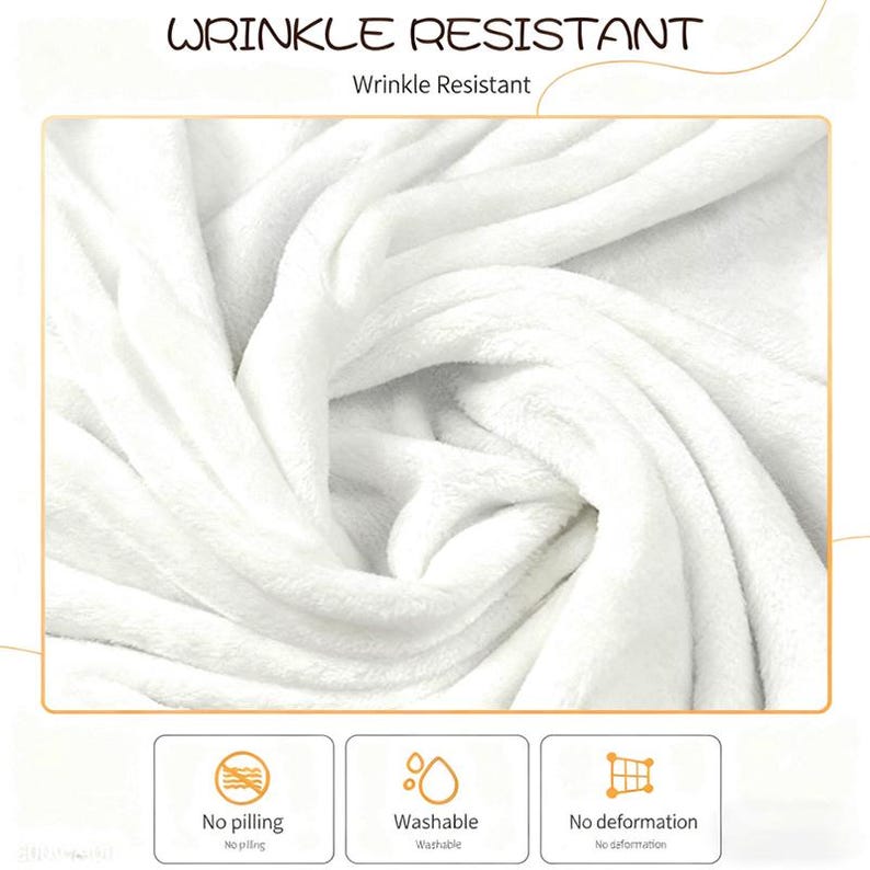 May include: A close-up of a white, fluffy blanket with the words "WRINKLE RESISTANT" at the top. The blanket is shown with a soft, textured appearance. The image also includes icons indicating the blanket is washable, no pilling, and no deformation.