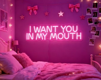 Pode incluir: Um quarto rosa com uma placa de néon que diz "I WANT YOU IN MY MOUTH". O quarto é decorado com luzes de corda, laços e estrelas. Uma cama com roupa de cama e almofadas rosa está em primeiro plano.