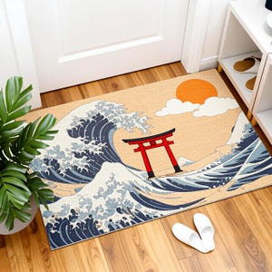 Könnte beinhalten: Rechteckige Fußmatte mit japanischem Design. Sie zeigt eine große Welle in Blau und Weiß, ein rotes Torii und eine untergehende Sonne. Der Hintergrund ist hellbeige, passend für den Eingang.