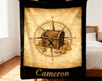 May include: A black blanket featuring a vintage map design with a compass rose, treasure chest, and gold coins. The blanket has a black border and the name "Cameron" in gold lettering.