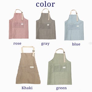 Puede incluir: Delantales a rayas en rosa, gris, azul, caqui y verde, cada uno con un bolsillo delantero y una correa ajustable para el cuello. La imagen incluye la palabra "color" y los nombres de los colores debajo de cada delantal.