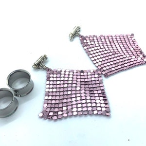 Puede incluir: Dos pares de pendientes de malla metálica rosa con cierres plateados y dos dilatadores de oreja plateados.