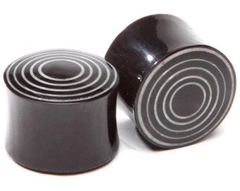 Könnte beinhalten: Paar schwarze und weiße Holz-Ohrstecker mit konzentrischem Kreisdesign.