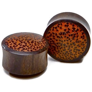 May include: Pair of brown wood ear gauges with a brown and orange patterned inlay.