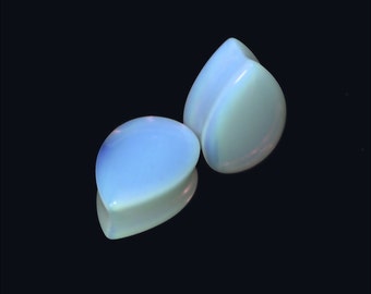 May include: Two teardrop-shaped opalite plugs, one on top of the other, against a black background.