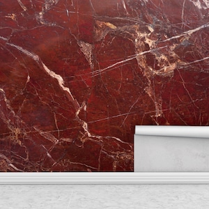 Può includere: Carta da parati in marmo rosso con venature bianche e bordo arrotolato. La carta da parati è parzialmente installata su una parete, rivelando il motivo. Il tema è l'arredamento e il design d'interni.