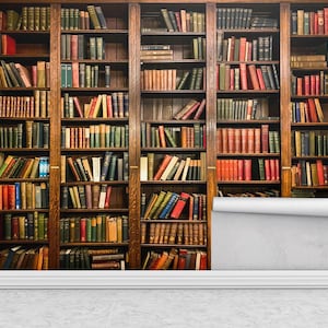May include: A wallpaper mural depicting a classic library scene. The image showcases a series of wooden bookshelves filled with a variety of books in different colors. The mural is partially unrolled, revealing a white backing.