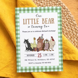 May include: A rectangular birthday invitation card with a green and white gingham border. The text reads Our LITTLE BEAR is turning two, Michael's birthday, November 23, 3 PM - 5 PM, 196 Wilson St, Hillsboro, KS 45747, RSVP to Amanda 737-465-8132. Features a cat, duck, bear, owl, and chicken.