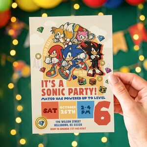 May include: A rectangular party invitation featuring Sonic the Hedgehog, Tails, Knuckles, Amy Rose, and Shadow. The text reads: IT'S A SONIC PARTY! MATEO HAS POWERED UP TO LEVEL 6. SAT OCTOBER 26TH 2-4 PM, 196 WILSON STREET, HILLSBORO, KS 55328, RSVP TO AMANDA 737-465-8567.