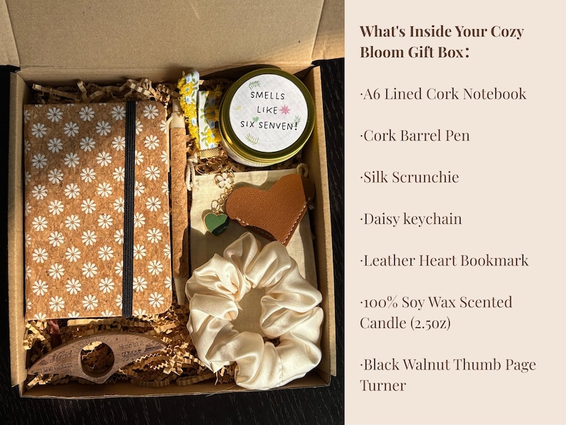 May include: A gift box filled with a cork notebook, pen, scrunchie, keychain, bookmark, candle, and page turner. The notebook has a daisy pattern. The candle reads "Smells Like Six Senven!"