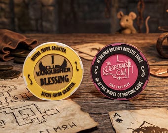 May include: Two circular gaming tokens. The yellow token features black text reading "Club Vanquisher Blessing" and "Divine Favor Granted." The pink token features black text reading "The Desperado Club" and "At the high roller's roulette table or at the wheel of fortune game."