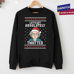 May include: Black sweatshirt with a festive design. The graphic features a woman wearing a Santa hat, with the text "LET'S GET ABSOLUTELY TWATTED" in white. The design includes red and white snowflake patterns.