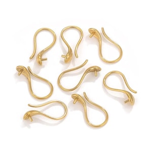 May include: Gold-colored earring hooks in a snake-like design. The hooks have a curved body with a small, round post at the end for attaching beads or charms. The earrings are made of a shiny, metallic material.