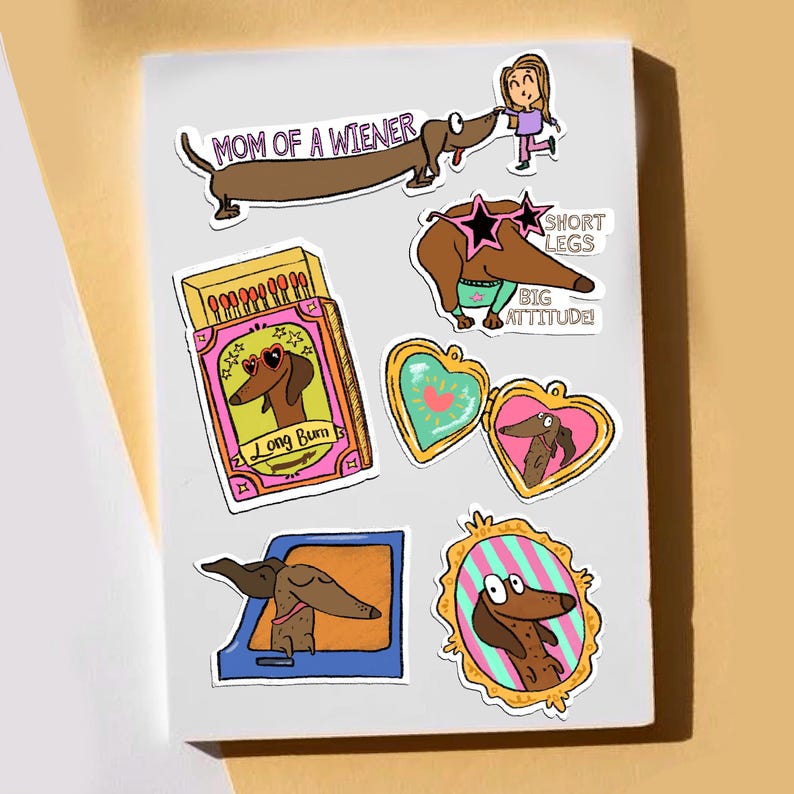 May include: A collection of colorful stickers featuring dachshund dogs in various poses. One sticker reads "MOM OF A WIENER", another says "SHORT LEGS BIG ATTITUDE!" and another says "LONG BUM". The stickers are on a white background.