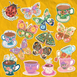 May include: A collection of colorful stickers featuring butterflies, teacups, and a ladybug on a yellow background. The butterflies have floral patterns in various colors. The teacups are decorated with flowers and filled with a brown liquid.