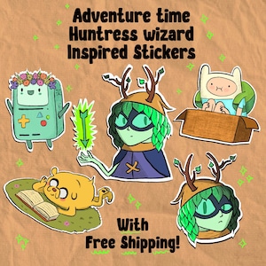 May include: A collection of Adventure Time-inspired stickers featuring characters like BMO, Jake, Finn, and Huntress Wizard. The stickers are colorful and cartoonish, with a brown background and the text "Adventure Time Huntress Wizard Inspired Stickers".