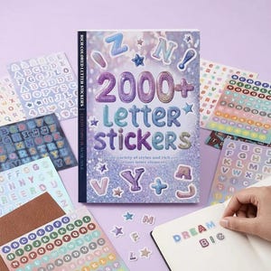 Könnte beinhalten: Ein Buch mit dem Titel 2000+ Letter Stickers mit einem glitzernden lila und blauen Einband, der verschiedene Alphabet-Aufkleber zeigt. Mehrere Bögen mit bunten Buchstabenaufklebern in verschiedenen Schriftarten und Stilen liegen ausgebreitet.