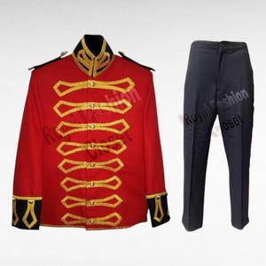 May include: A bright red military-style jacket featuring gold braided trim, a high black collar, and black cuffs with gold accents, paired with solid dark navy blue trousers. The jacket includes a front button closure with decorative gold loops.