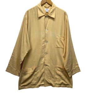 May include: A set of three ceramic mugs with a speckled, matte finish. The mugs are in shades of cream, light gray, and dark gray. Each mug has a simple, minimalist design and a rounded handle.