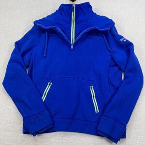 May include: A royal blue pullover sweatshirt featuring a high collar with a half-zip closure, accented by bright neon yellow trim along the zipper tape. The garment includes two front pockets with matching neon yellow zippered closures.