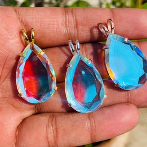 Elegant sterling silver necklace featuring a teardrop Angel Aura Quartz crystal. The iridescent rainbow sheen adds a magical and celestial touch to this dainty pendant jewelry.