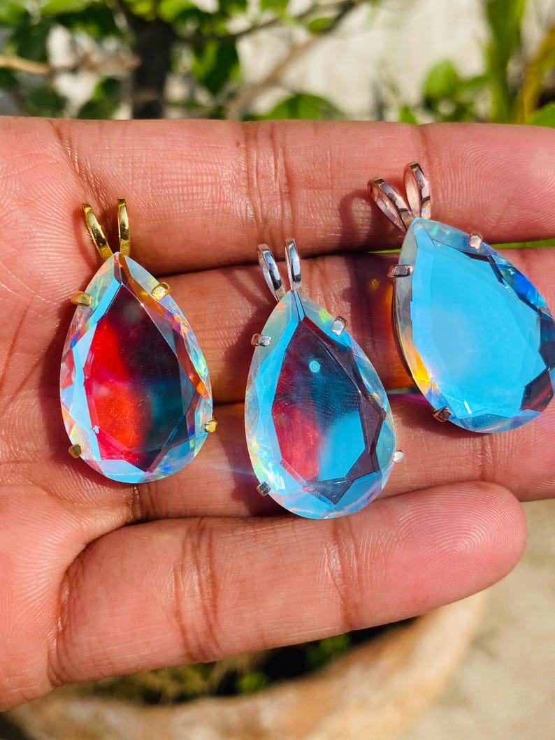 Elegant sterling silver necklace featuring a teardrop Angel Aura Quartz crystal. The iridescent rainbow sheen adds a magical and celestial touch to this dainty pendant jewelry.