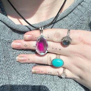 Close view of rainbow Angel Aura Quartz teardrop pendant set in solid 925 sterling silver. Dainty crystal necklace with mystical glow, perfect for everyday wear or meaningful gift giving.
