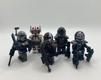 May include: Five Lego minifigures of Star Wars characters. The figures are predominantly black, with red and white detailing. Each figure is holding a weapon. The figures are arranged against a white background.