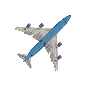 Puede incluir: Diseño bordado de un avión con fuselaje azul claro y alas con un patrón beige y gris. El avión tiene cuatro detalles de motor morados sobre un fondo blanco.