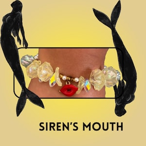 May include: A bracelet with a red lip charm, iridescent crystals, and pearl accents. The bracelet is adorned with translucent, irregular-shaped beads. The text "SIREN'S MOUTH" is displayed at the bottom of the image, with black mermaid silhouettes on a yellow background.
