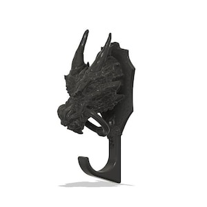 May include: A black dragon head wall hook. The hook features a detailed dragon head with horns, a ring, and a curved hook for hanging items. The dragon head is mounted on a shield-shaped plaque.