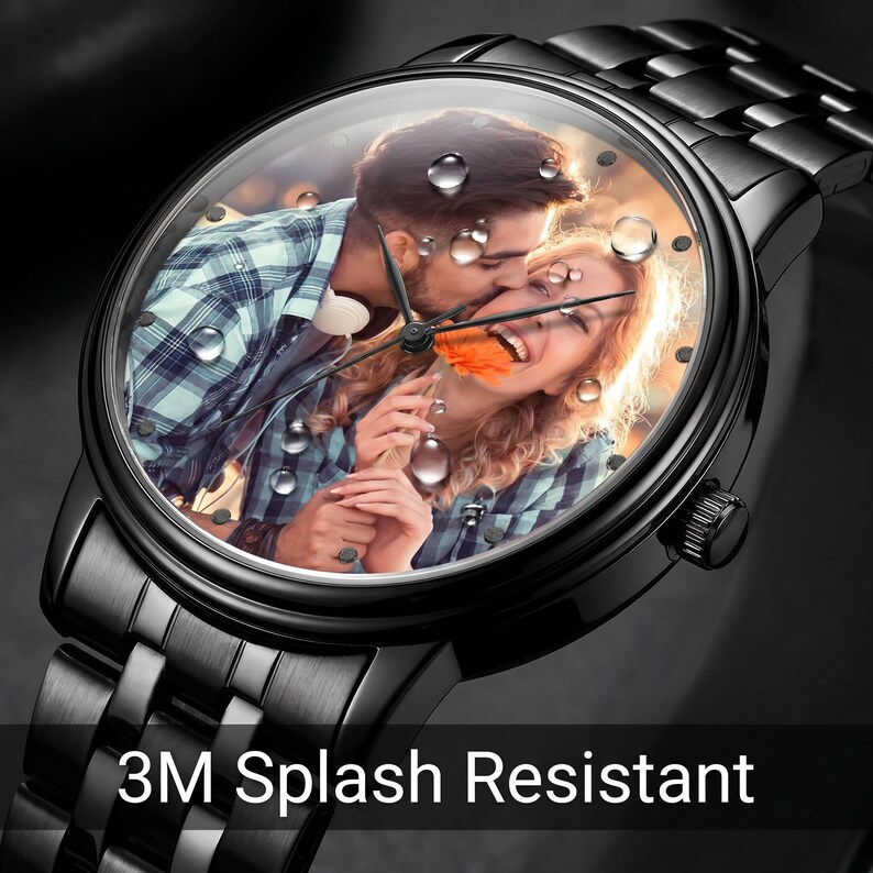 K&ouml;nnte beinhalten: Schwarze Armbanduhr mit einem Foto eines sich k&uuml;ssenden Paares auf dem Zifferblatt. Die Uhr hat ein schwarzes Metallarmband und ein klares Kristall. Der Text "3M Splash Resistant" wird am unteren Rand der Uhr angezeigt.