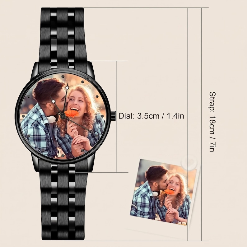K&ouml;nnte beinhalten: Schwarze Armbanduhr mit einem Foto eines Paares auf dem Zifferblatt. Das Zifferblatt der Uhr hat einen Durchmesser von 3,5 cm und das Armband ist 18 cm lang. Die Uhr hat ein schwarzes Metallarmband und ein kleines Foto desselben Paares.