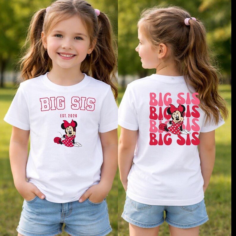Pu&ograve; includere: Una t-shirt bianca a maniche corte con una grafica rossa di Minnie Mouse e il testo BIG SIS EST. 2026 sul davanti. Il retro presenta un motivo ripetuto di testo ondulato rosa e rosso BIG SIS con una grafica centrale di Minnie Mouse.