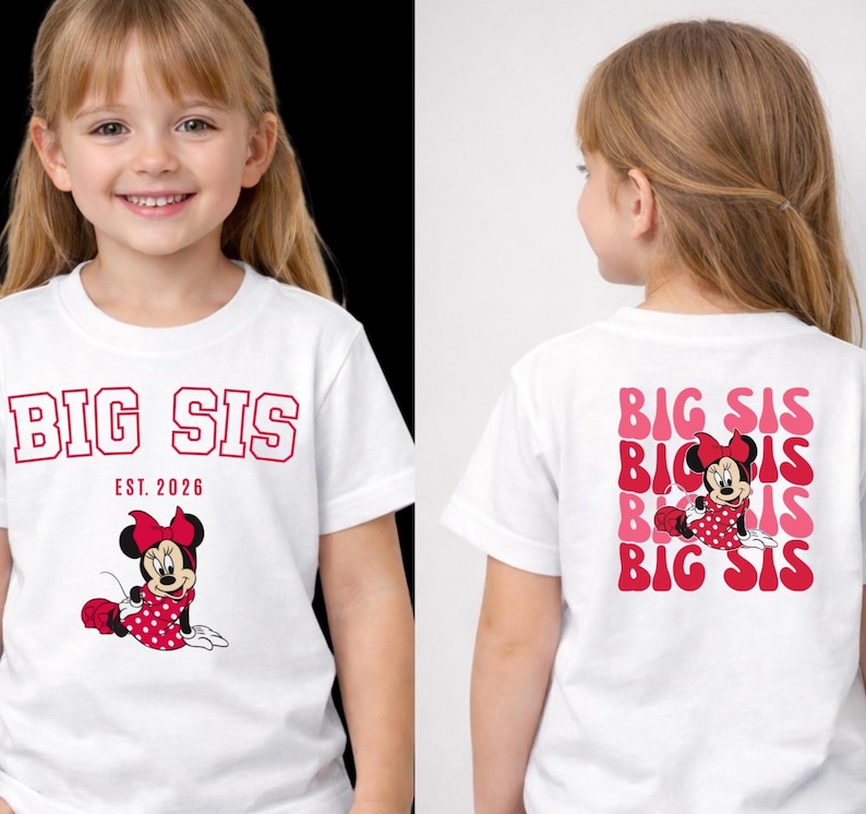 Pu&ograve; includere: Una t-shirt bianca a maniche corte con una grafica rossa di Minnie Mouse e il testo BIG SIS EST. 2026 sul davanti. Il retro della maglietta mostra il testo BIG SIS ripetuto in un carattere ondulato rosso e rosa con Minnie Mouse.