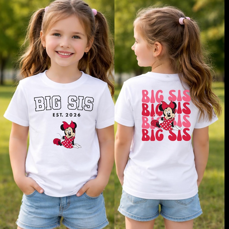 Pu&ograve; includere: Una t-shirt bianca a maniche corte con il testo BIG SIS EST. 2026 e una grafica di Minnie Mouse sul davanti. Il retro mostra il testo BIG SIS ripetuto in rosa e rosso con una grafica centrale di Minnie Mouse con un vestito a pois rossi.