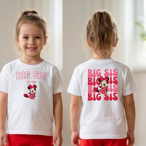 Pu&ograve; includere: Una t-shirt bianca a maniche corte con una grafica rossa di Minnie Mouse e il testo BIG SIS EST. 2026 sul davanti, e un motivo ripetuto di testo BIG SIS rosso e rosa con una grafica di Minnie Mouse sul retro del capo.