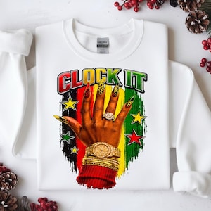 Puede incluir: Una sudadera blanca de manga larga con un estampado gráfico de una mano con uñas largas de estampado de leopardo, un reloj dorado y pulseras doradas apiladas. El texto CLOCK IT está impreso sobre la mano, sobre un fondo de pinceladas rojas, amarillas y verdes con pequeñas estrellas.