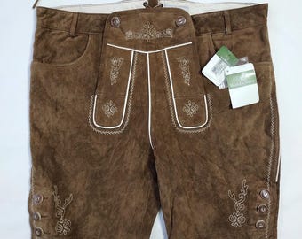 May include: Brown leather shorts with white embroidered detailing and decorative buttons. The shorts have a front flap with buttons and a drawstring waistband. A tag is attached to the shorts.
